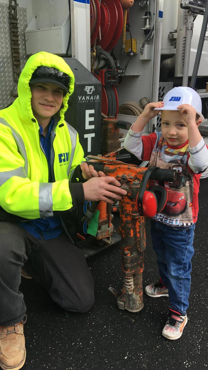 SJW employee with a child holding a tool 