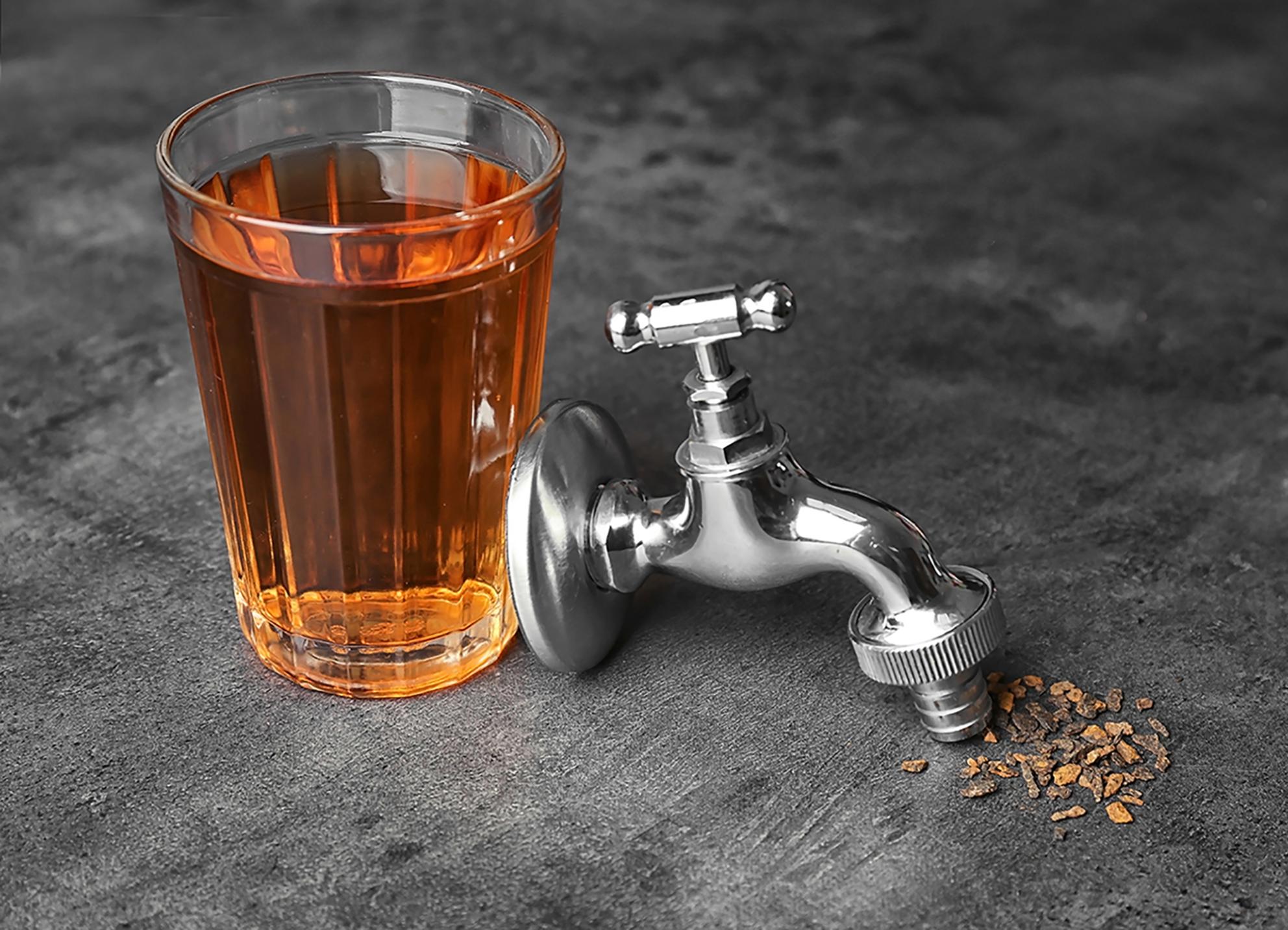 glass of brown cold water with a spigot 