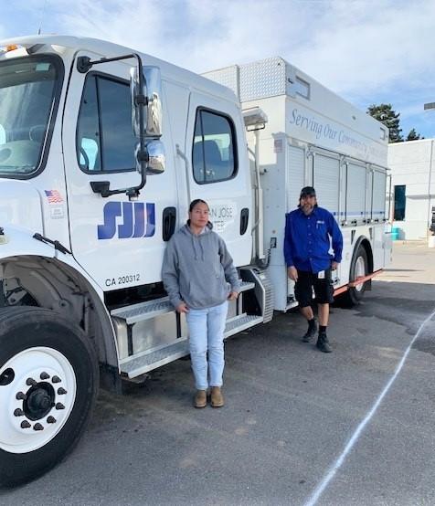 Lucy Perez and Fabian Rosales standing next to their truck