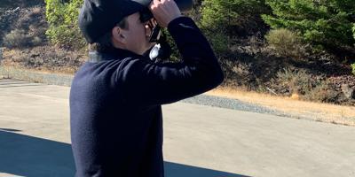 Jared Lewis looking through binoculars