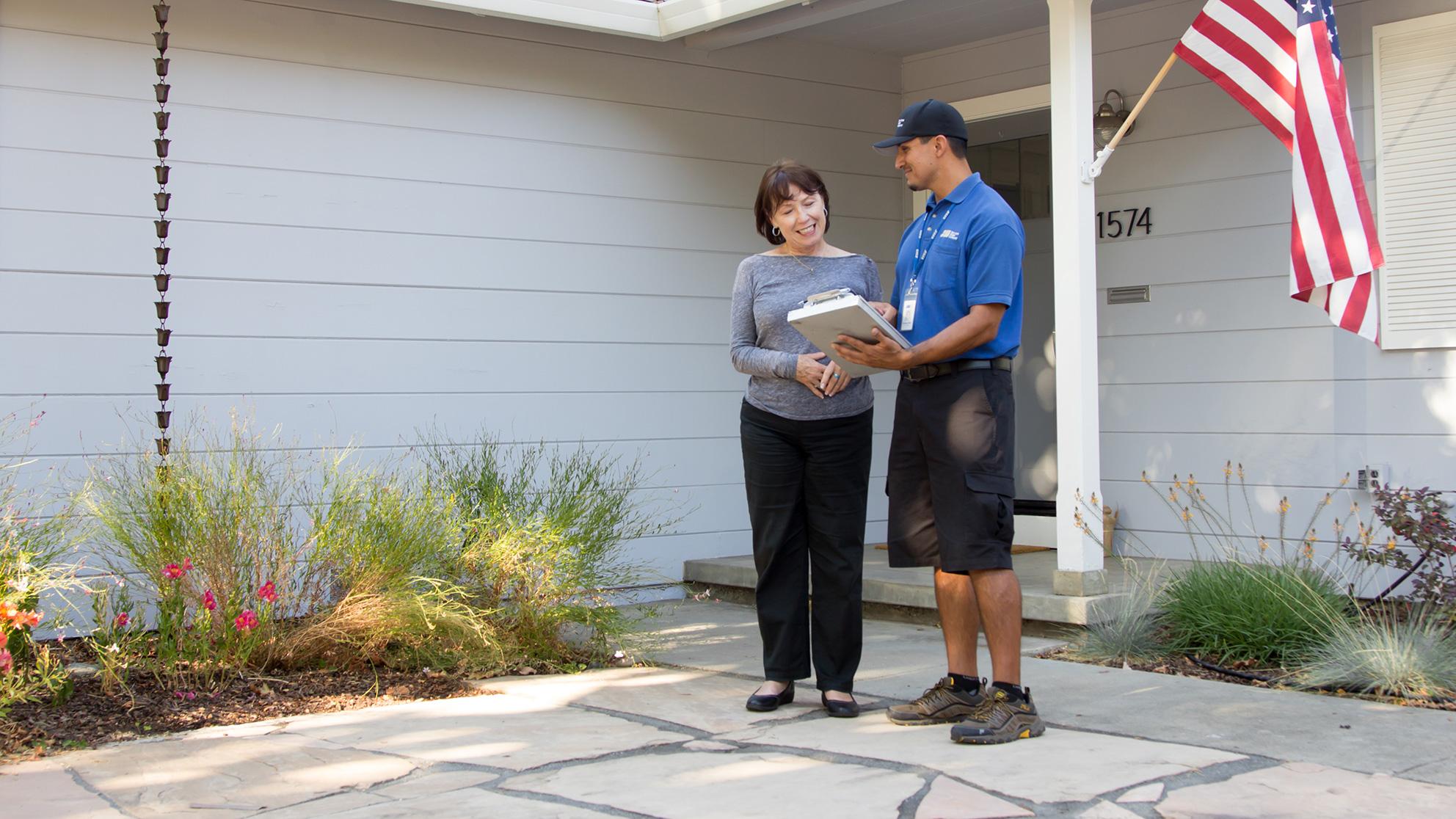an employee with a customer outside their house