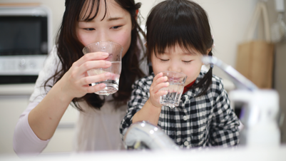 mother and daughter drinking a glass of water