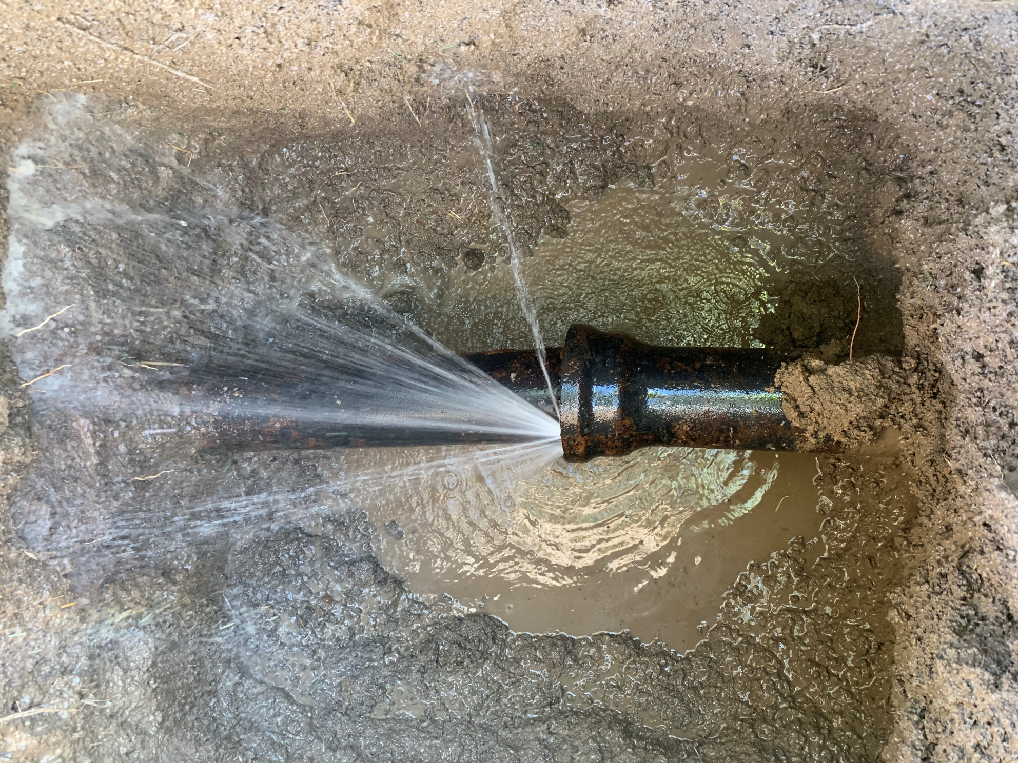an underground pipe spewing water